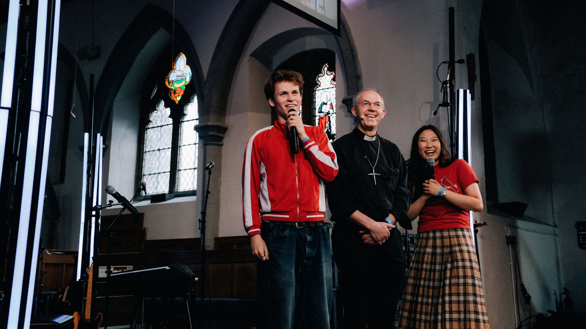 Archbishop Justin Welby stands between two of the young presenters of the evening as they talk with people joining the livestream.